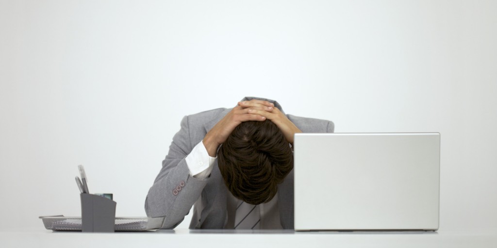 Businessman sitting at desk with head down